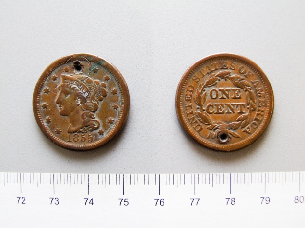 Eine Waage mit zwei Münzen darauf, wobei eine ein 1855 Capped Bust Half Cent mit sichtbarem Text und Zahlen ist.