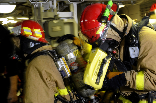 Feuerwehrleute in Schutzausrüstung arbeiten an einem Flugzeug während einer Übung.