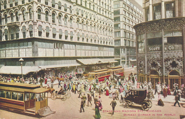 Altes Schwarz-Weiß-Foto einer belebten Stadtstraße mit Fußgängern, Kutschen und Gebäuden im Hintergrund, mit Text am unteren Rand.