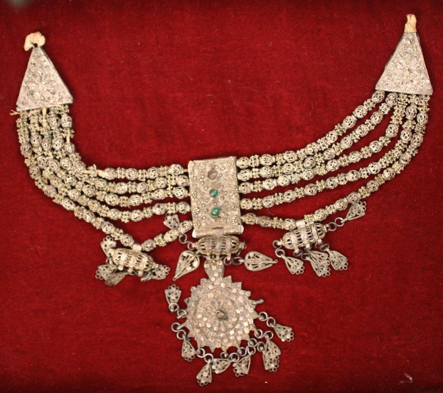 Silberschmuck mit Smaragden und Diamanten auf rotem Samt