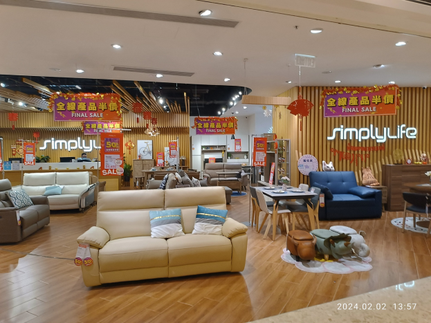 Ein Möbelgeschäfts-Innenraum mit Sofas, Tischen, Stühlen, Hockern, Deckenleuchten und Informationsschildern auf Chinesisch, mit einem Wasserzeichen im rechten unteren Eck.