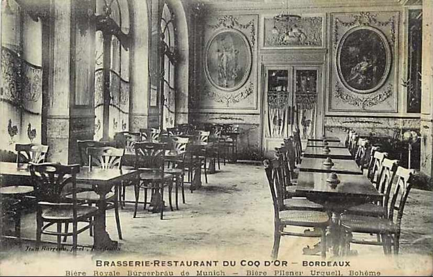 Schwarz-weiß-Foto eines alten Brasserie-Restaurant-Interieurs in Coq d'or, Bordeaux, Frankreich, mit Tischen, Stühlen, Wandgemälden, einer zentralen Tür und Text am unteren Rand.