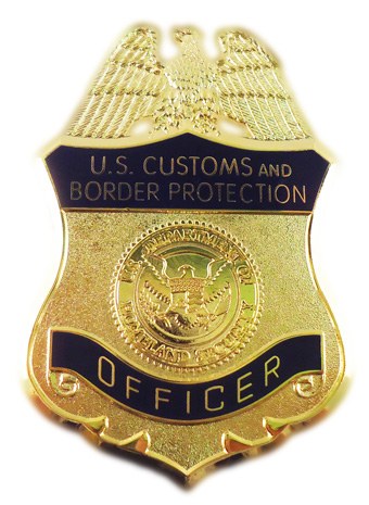 Goldabzeichen mit der Aufschrift "U.S. Customs and Border Protection Officer" auf einem weißen Hintergrund.