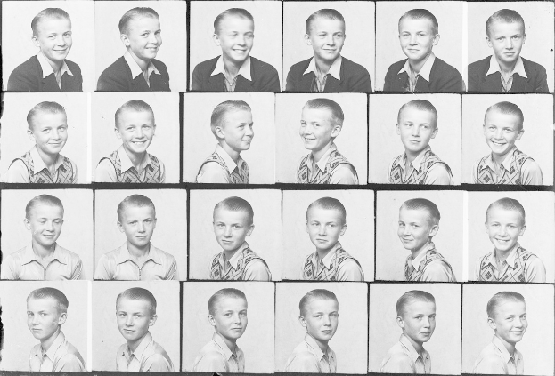 Ein Schwarz-Weiß-Foto eines strahlenden jungen Jungen mit ordentlich gekämmtem Haar, hellen Augen und einem Ausdruck von Glück.