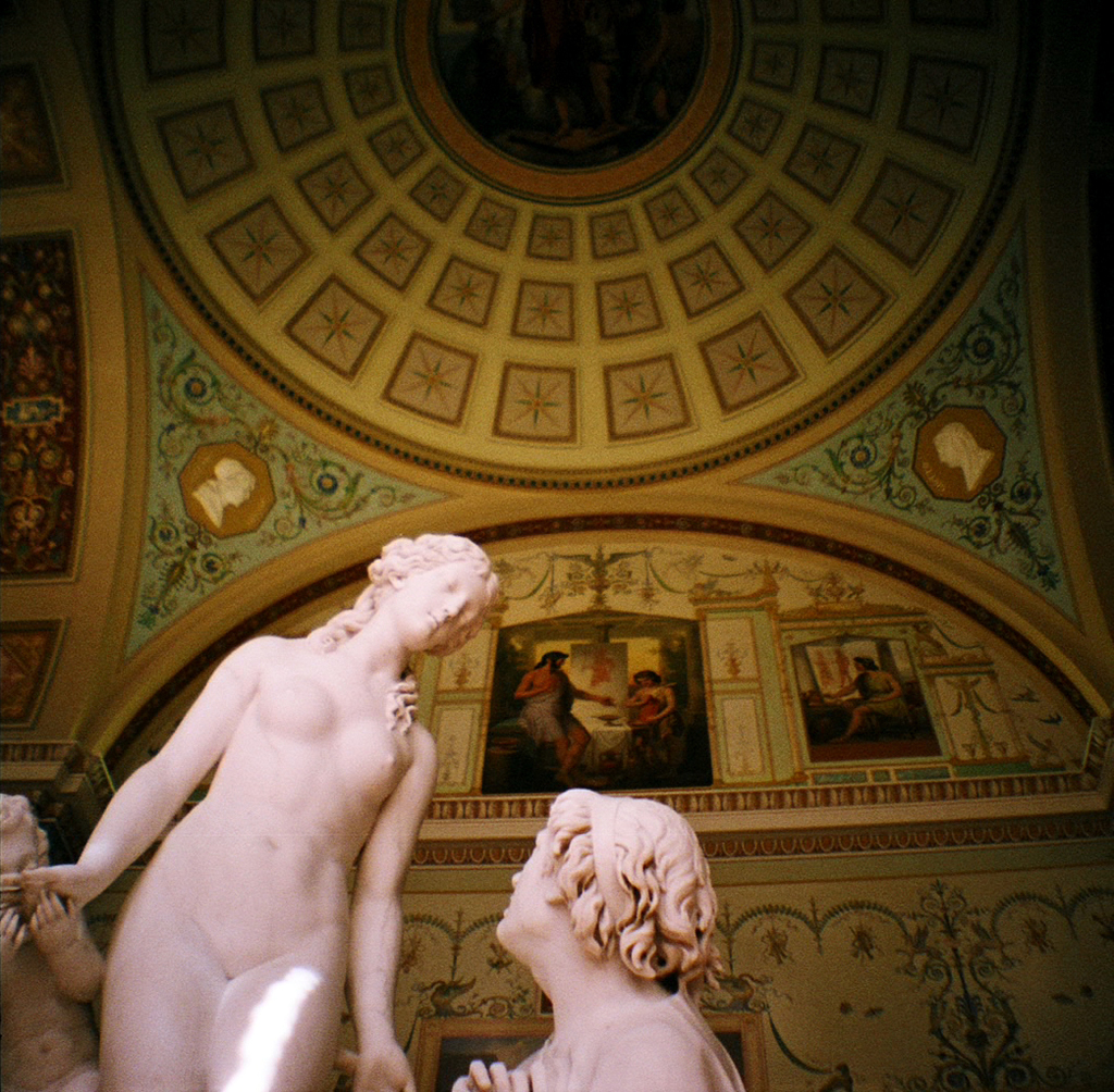 Skulpturen in der Mitte und auf der linken Seite eines Raums mit Gemälden an der Hintergrundwand.