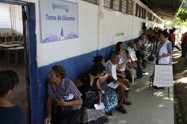 Menschen sitzen auf Bänken vor einem Gebäude und warten in einer Schlange, um an einer Wahlurne in Guadalajara, Mexiko, zu wählen.