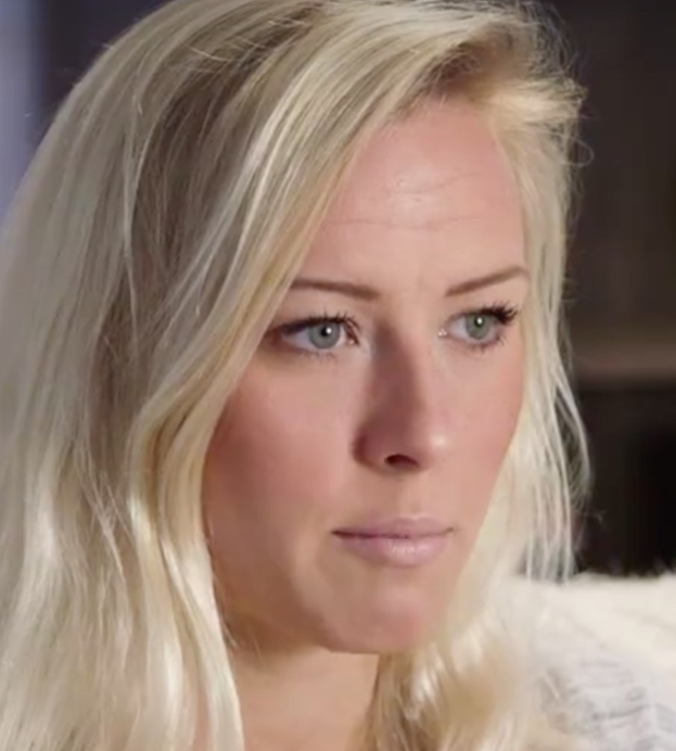 Blonde Frau mit blauen Augen in Not, Hintergrund unscharf, möglicherweise aufgrund der Zwangspause.