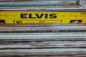 Ein ordentlicher Stapel Elvis-Presley-Platten auf einem Tisch, mit einigen überlappenden und sichtbaren Titeln, vor einem unscharfen Hintergrund.