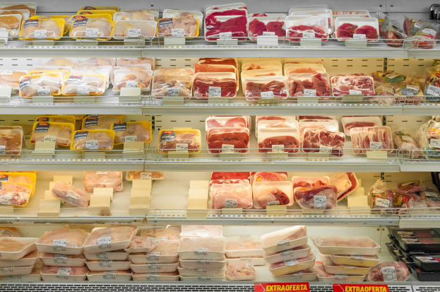 Ein gut organisierter Gemüseabteilung mit verschiedenen Fleischsorten auf Regalen, jeweils mit Preisschildern.